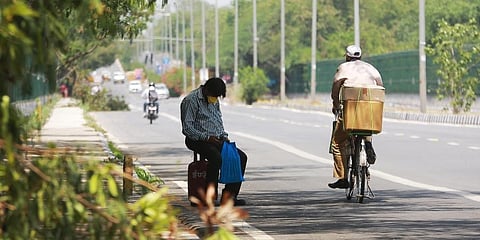 With no help in sight a man carrying an LPG cylinder takes a break on a deserted road during the lockdown in New Delh. (Photo | Shekhar Yadav, EPS)
