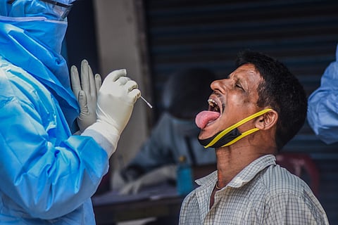 A health worker collecting swab sample at ID market in Bhubaneswar on Tuesday. (Photo | Biswanaath Swain/EPS)