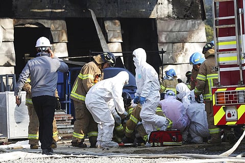 Firefighters prepare to carry an injured worker after a fire engulfed a construction site in Icheon, South Korea on Wednesday. (Photo | AP)