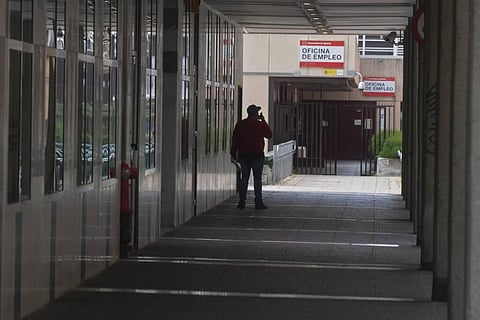 A man speaks on his phone outside an unemployment office in Madrid, Spain. (Photo | AP)