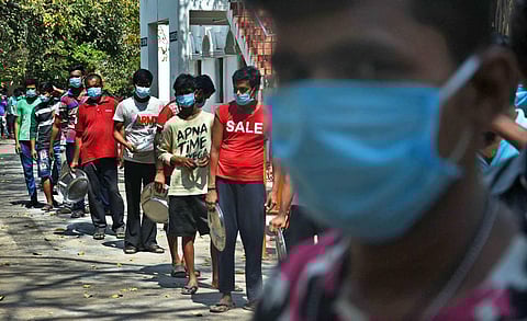 The Migrant labours stand in queue to get their lunch at Gurunanak college in Velachery. (Photo | Ashwin Prasath, EPS)