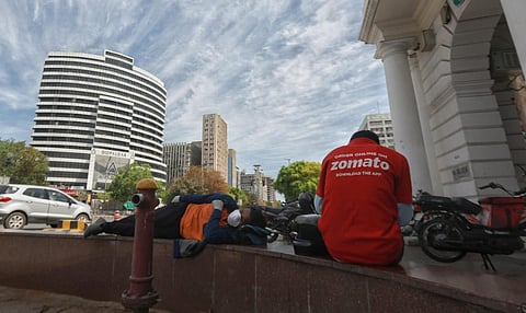 Zomato and Swiggy delivery boys sitting at connaught place in New Delhi. (Photo | Shekhar Yadav, EPS)