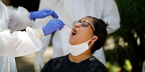 Medical team collects a swab sample of a woman during the nationwide lockdown in wake of the coronavirus pandemic, in Ahmedabad. (Photo| ANI)