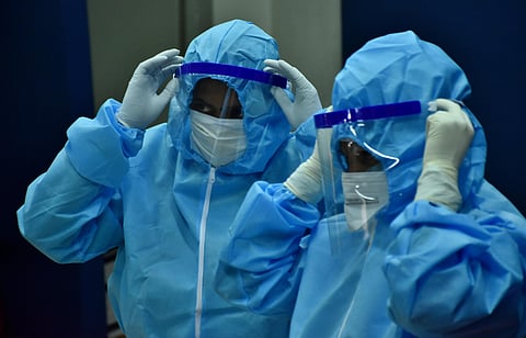 Healthcare workers getting ready by donning personal protective equipment PPE with face shields before Testing swabs through RT-PCR method in Coimbatore on Wednesday. (Photo | U Rakesh Kumar/EPS)