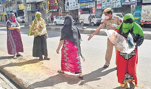 Sex workers queue up to collect ration being distributed at GB Road by RSS workers. (Photo | PTI)