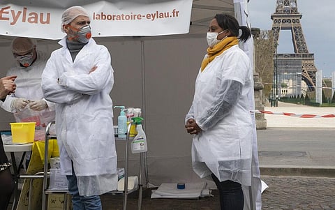 Biologist Christophe Delaunay, left, and nurse Veronique Boucher awaiting patients at a coronavirus drive-thru testing site in Paris, Monday, April 6, 2020. (Photo | AP)