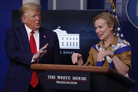 President Donald Trump reacts as Dr. Deborah Birx, White House coronavirus response coordinator, speaks about her granddaughter's fever as she speaks about the coronavirus in the James Brady Press Briefing Room of the White House, Monday, April 6, 2020, i