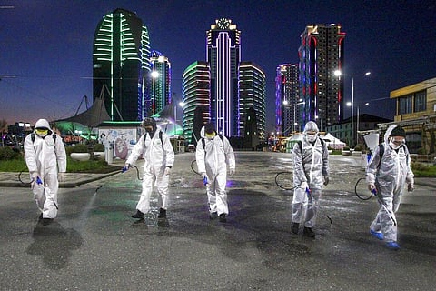 Municipal workers wearing protective suits spray disinfectant in an area in the center of Grozny, Russia, Monday, April 6, 2020. (Photo | AP)