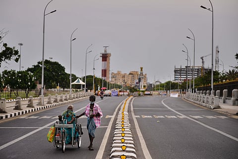 A man walks with a differently able woman on tricycle on the 14th day of lockdown as the sky turns overcast giving relief from scorching heat at Kamarajar Promenade in Chennai on Tuesday. (Photo | Debadatta Mallick/EPS)
