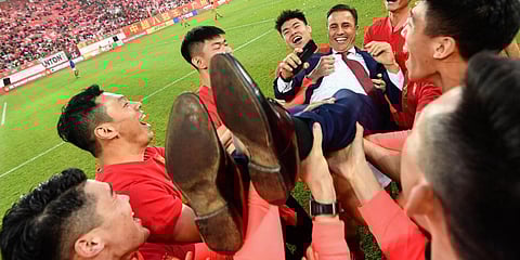 Players of Guangzhou Evergrande lift up their head coach Fabio Cannavaro celebrate after defeating Shanghai Shenhua to win the Chinese Super League (CSL) football championship in Guangzhou. (File photo| AFP)