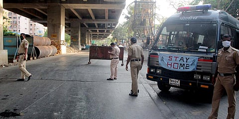 Police personnel stand guard as a police van with message Stay Home seen, during the lockdown to curb the spread of coronavirus at Kandivali in Mumbai. (File photo| ANI)