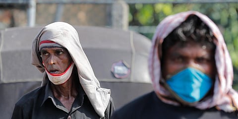 Daily wage laborers wait to find work at a market area during a curfew imposed to stop the spread of the coronavirus in Colombo. (Photo| AP)