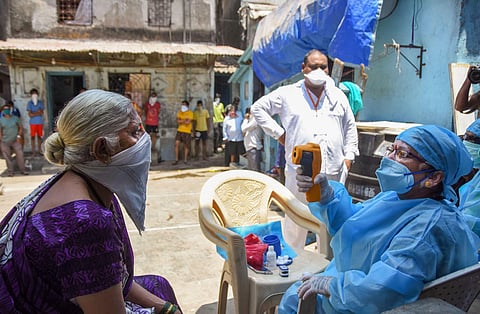 Health workers wearing protective suits screen resident of Dharavi during a house-to-house health survey after detection of some COVID-19 positive cases during the nationwide lockdown in Mumbai Wednesday April 29 2020. (Photo | PTI)