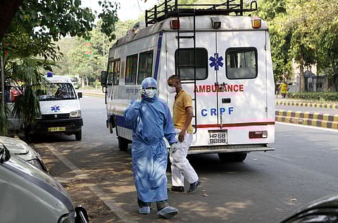 A CRPF staff wearing PPE kit talks on phone near a CRPF ambulance at Ram Manohar Lohiya Hospital in New Delhi during the nationwide lockdown to control the spread of coronavirus on Tuesday. (Photo | Anil Shakya/EPS)