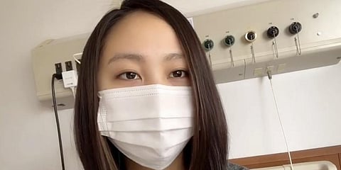 In this April 19, 2020, image made from the Youtube account of Arisa Kadono, she speaks to her smartphone video at a hospital, in Himeji, western Japan. Soon after Kadono tested positive for the coronavirus and hospitalized in early April, her friends let