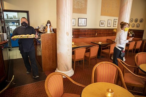 Chef Radeke (L) and Stephanie Thiem prepare to reopen Cafe Prag in Schwerin, northeastern Germany on May 9, 2020 amid the ongoing Covid-19, coronavirus pandemic. (Photo | AFP)