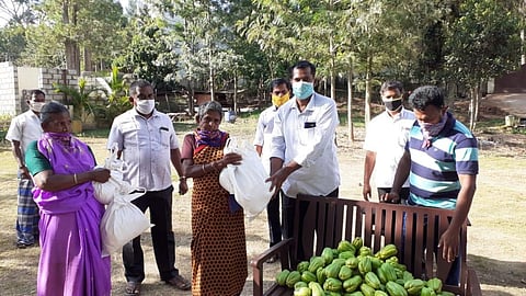 Shine Treechy members handing out groceries to daily wagers in Sirumalai, Dindigul on Saturday. (Photo | Express)