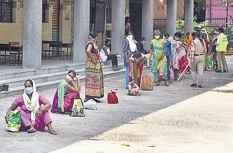 People wait in a queue to collect food items. (Photo | Parveen Negi, EPS)
