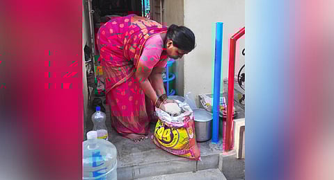 A woman showing damaged rice due to gas leak (Photo | G Satyanarayana, EPS)