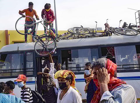 Migrants load their bicycles before boarding a bus to travel to their native places during the ongoing COVID-19 nationwide lockdown in Patna Wednesday May 13 2020. (Photo | PTI)