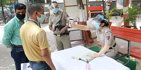 A man undergoes temperature test as he arrves at RK Puram Police Station amid ongoing COVID-19 lockdown in New Delhi. (Photo| Shekhar Yadav, EPS)