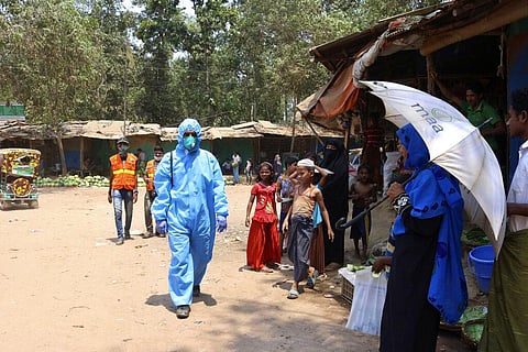 a health worker from an aid organization walks wearing a hazmat suit at the Kutupalong Rohingya refugee camp in Cox's Bazar, Bangladesh. (Photo | AP)