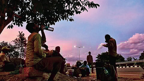 Migrant workers from Bihar, who started walking from Bengaluru to their homes, rest near Devanahalli.