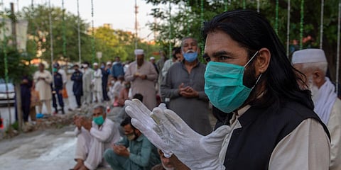 People pray ahead of Iftar at a food distribution point during the Muslim fasting month of Ramzan during a nationwide lockdown in Pakistan. (Photo| AP)