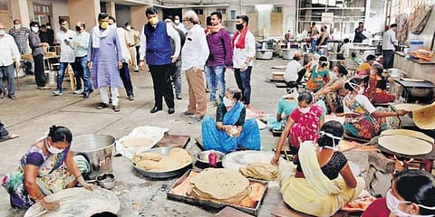 Former Maharashtra CM and BJP leader Devendra Fadnavis visits a party-run community kitchen preparing food packets for the needy at Patidar Bhawan in Nagpur on Friday. (Photo | PTI)