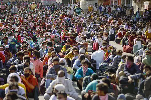 Migrants wait for a means of transport to reach a railway station and board a special train to their native place in Uttar Pradesh during the ongoing COVID-19 nationwide lockdown in Ahmedabad Thursday May 14 2020. (Photo | PTI)