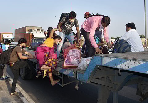 Migrants board a trailer of a truck at Gazipur on the Delhi-UP border during their journey to reach home in New Delhi Friday May 15 2020. (Photo | PTI)