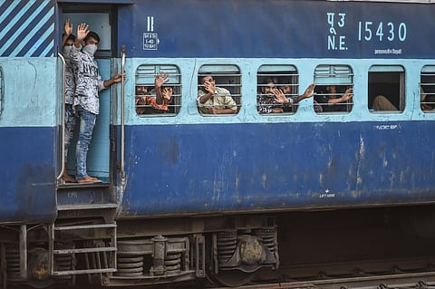 Migrants wave as they board a train to their native places in Bihar during the ongoing COVID-19 nationwide lockdown in Ghaziabad Thursday May 16 2020. (Photo | PTI)