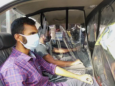 Transparent mica sheets separating driver and passengers in a cab in Coimbatore.