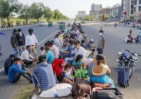 Migrants wait for a transport to reach the railway station and board a special train to their native places in Uttar Pradesh amid the ongoing COVID-19 lockdown in Ahmedabad Thursday May 14 2020. (Photo | PTI)