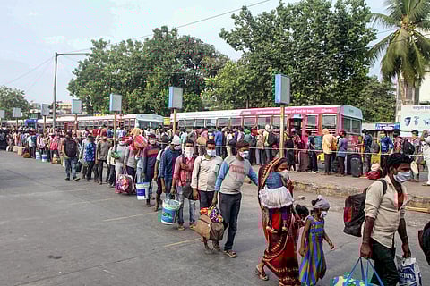 Migrants carry their luggage after stepping off a bus outside the Boriwali station as they wait to catch a train to Varanasi during the ongoing COVID-19 nationwide lockdown in Mumbai Saturday May 16 2020. (Photo | PTI)