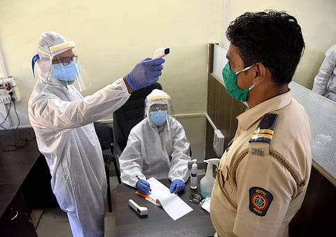 Thermal screening of a policeman conducted during the ongoing nationwide COVID-19 lockdown. (Photo | PTI)
