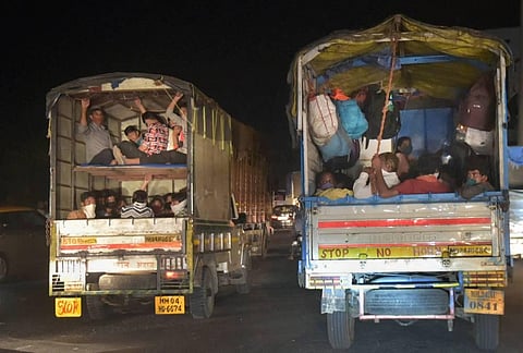 Migrants from northern states ride cargo vehicles on Mumbai-Nashik highway to reach their native places during the ongoing COVID-19 lockdown in Thane late night on Friday. (Photo | PTI