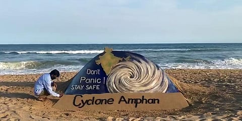 Sand artist Sudarsan Pattnaik gives final touches to his sand sculpture on cyclone Amphan with the message. (Photo| ANI)