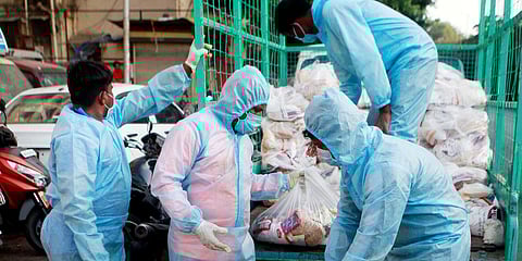 People wear protective suits as they distribute grocery packets in Mumbai. (FIle photo| ANI)