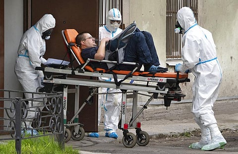 Emergency doctors wearing protective equipment transport a man to a hospital for COVID-19 patients in St.Petersburg, Russia. (Photo | AP)