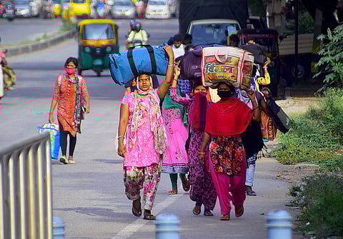 Migrant labourers walking to their native places at the Tumkur Road in Bengaluru. (Photo | Pandarinath B/EPS)