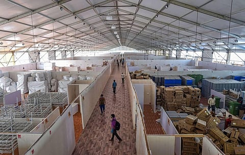 Workers carry out construction work at India's first open ground quarantine and isolation facility with 1 008 beds for semi-critical coronavirus patients at BKC in Mumbai Saturday. (Photo | PTI)