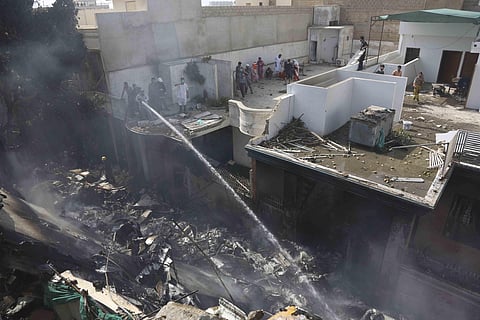 Fire brigade staff try to put out fire caused by plane crash in Karachi. (Photo | AP)
