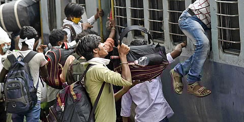 Migrant boards a train at Danapur station to reach their native places, during the ongoing COVID-19 nationwide lockdown in Patna. (File photo| ANI)