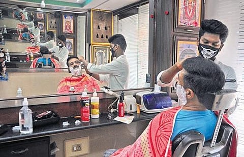 A barber at work in Vijayawada on Saturday. (Photo | EPS/Prasant Madugula)