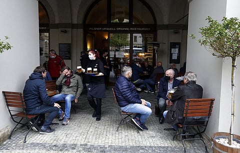 People are served at a restaurant terrace in Prague, Czech Republic. (Photo | AP)