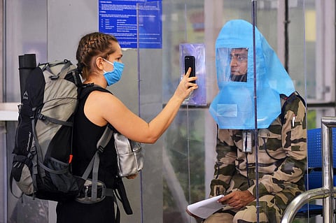 A passenger shows her e-ticket to a security officer at the Chennai airport on Monday. (Photo | Debadatta Mallick, EPS)