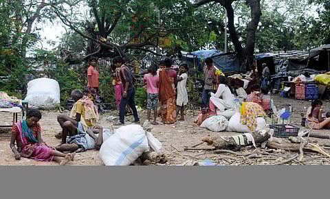 People sit outside their house as the roof of their houses got blown up during the cyclone Amphan, in Kolkata. (Photo| ANI)