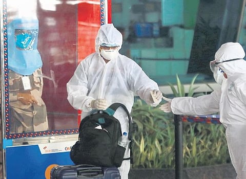 An air passenger wearing PPE suit arrives at IGI Airport in Delhi as domestic flights resumed on Monday | Shekhar YADAV