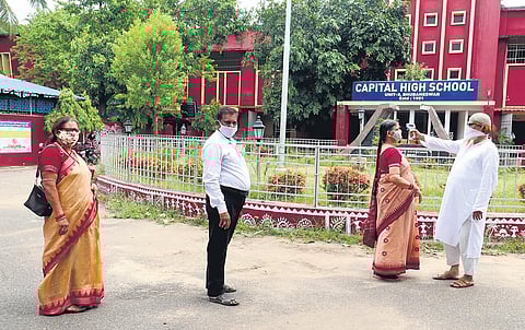Teachers undergo thermal screening before entering evaluation centre at Capital High School in Bhubaneswar on Tuesday (Photo | Irfana, EPS)